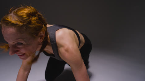 Foto-De-Estudio-De-Una-Mujer-Madura-Vistiendo-Ropa-De-Gimnasio-Haciendo-Ejercicio-De-Escalador-De-Montaña-5